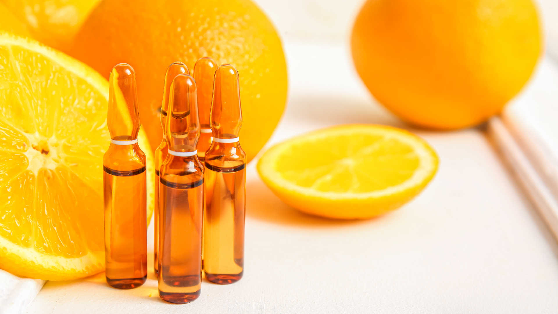Ampoules of intravenous vitamin C beside some oranges