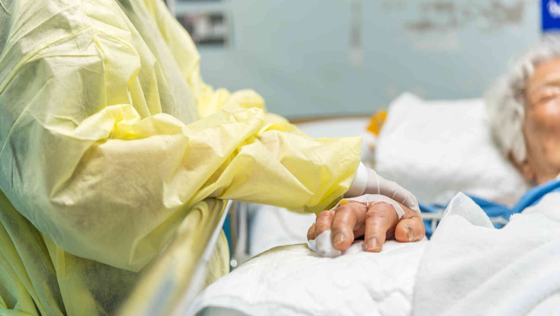 Family member holding the hand of a patient