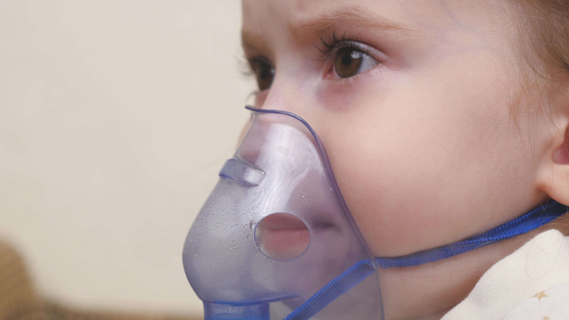 Infant receiving oxygen via a face mask